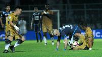 Striker Arema, Cristian Gonzales, jatuh bangun dihadang bek Persib saat kedua tim bentrok di Stadion Kanjuruhan, Malang (12/8/2017). (Bola.com/Iwan Setiawan)