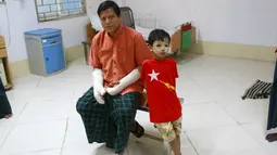 Naing Nan Lynn bersama anaknya saat dirawat di Rumah Sakit, Yangon, Myanmar,  Rabu (4/11/2015). Anggota Oposisi Myanmar ini menderita luka serius setelah dipukul di kepala dan lengannya. (REUTERS/Soe Zeya Tun)