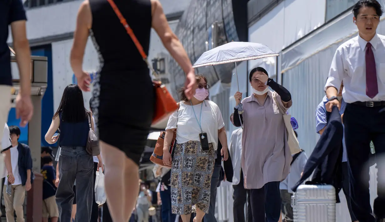 Suhu diperkirakan akan melampaui 41 derajat Celsius di beberapa area pedalaman wilayah Kanto. Tampak dalam foto, orang-orang berjalan di trotoar di Tokyo pada 5 Agustus 2025. (Kazuhiro NOGI/AFP)