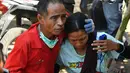 Seorang pria mencoba untuk menenangkan salah satu keluarganya saat  gempa susulan terjadi di Tanjung pulau Lombok, NTB, Kamis (9/8).(AFP/ ADEK BERRY)