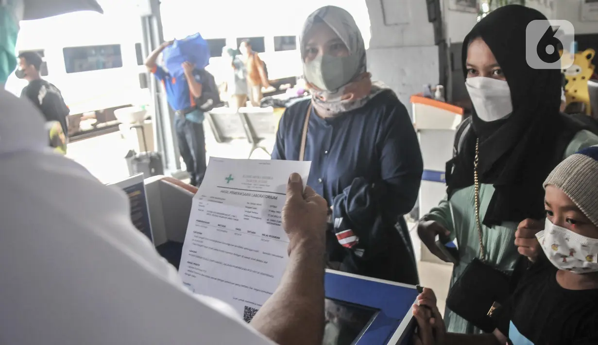 Petugas memeriksa kelengkapan syarat penumpang kereta api jarak jauh sebelum memasuki peron di Stasiun Pasar Senen, Jakarta Pusat, Minggu (17/7/2022). PT KAI mulai hari ini kembali memberlakukan syarat wajib bagi penumpang kereta jarak jauh, antara lain tes PCR bagi yang baru vaksin pertama dan tes antigen untuk vaksin kedua sebagai langkah mencegah penyebaran Covid-19. (merdeka.com/Iqbal S Nugroho)
