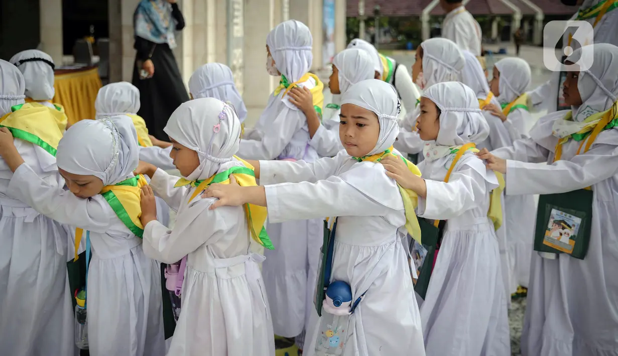 Murid TK saling memegang pundak rekannya saat mengikuti edukasi manasik haji anak di Masjid At-Tin, Jakarta, Selasa (28/2/2023). Manasik haji yang diikuti puluhan murid TK se-Kecamatan Pasar Rebo tersebut dalam rangka mengenalkan rukun Islam kelima yakni ibadah haji serta tata cara melaksanakannya kepada anak sejak usia dini. (Liputan6.com/Faizal Fanani)