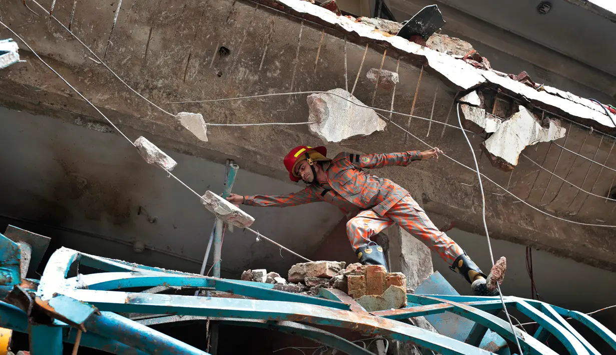 Petugas memeriksa puing-puing bekas ledakan di sebuah pabrik garmen di Dhaka, Bangladesh (4/7). insiden itu terjadi akibat ledakan mesin boiler di pabrik garmen Multifabs Limited. (AP Photo / AM Ahad)