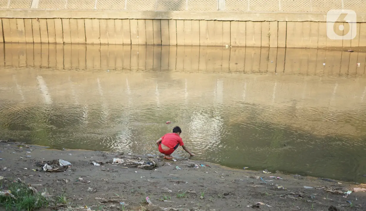 Anak-anak bermain di bantaran Sungai Ciliwung yang mengering, kawasan Kampung Melayu, Jakarta, Jumat (8/11/2019). Curah hujan yang tidak menentu menyebabkan sebagian bantaran Ciliwung masih mengalami kekeringan. (Liputan6.com/Immanuel Antonius)