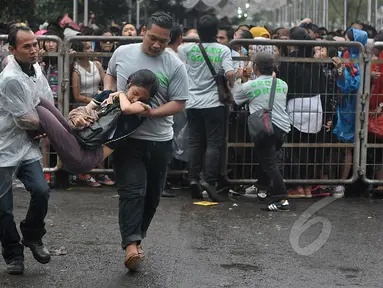 Sejumlah wanita pingsan saat mengantre untuk menonton konser One Direction, Senayan, Jakarta, Rabu (25/3/2015). Puluhan ribu orang rela mengantre untuk melihat konser One Direction. (Liputan6.com/Johan Tallo)