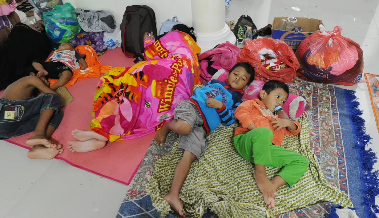 Anak-anak pengungsi bencana tsunami beristirahat di sebuah masjid di Tenjolahang, provinsi Banten, Rabu (26/12). Data sementara jumlah korban dari bencana tsunami Selat Sunda tercatat lebih dari 400 orang meninggal dunia. (Sonny TUMBELAKA / AFP)