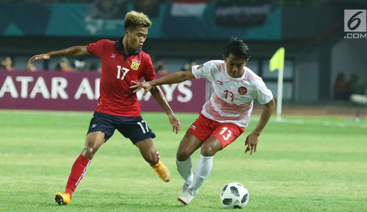 Pemain sayap Timnas Indonesia, Febri Hariyadi (kanan) berusaha mengecoh pemain Laos, Bounkong Bounphachan pada penyisihan Grup A Sepak Bola Asian Games 2018 di Stadion Patriot Candrabhaga, Bekasi, Jumat (17/8). (Liputan6.com/Helmi Fithriansyah)