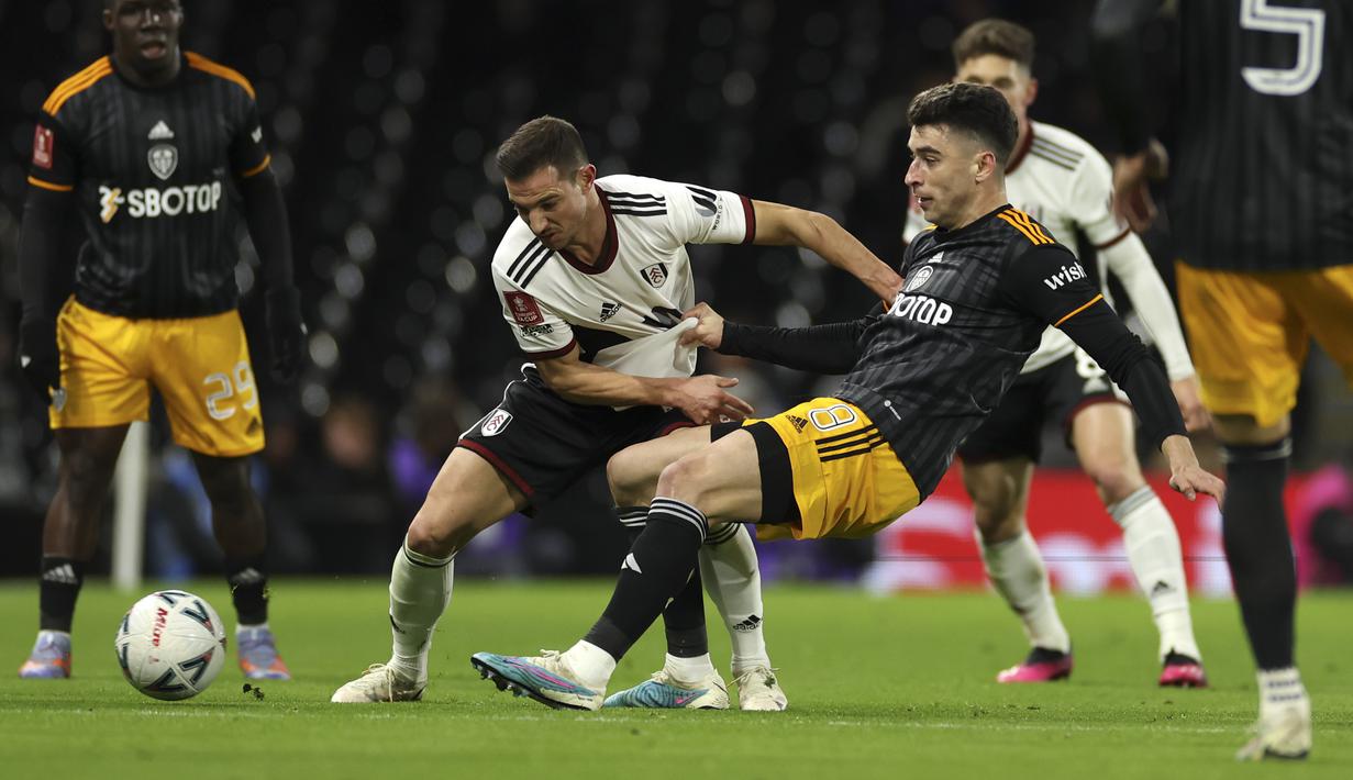 Bek Fulham Cedric Soares berebut bola dengan gelandang Leeds United Marc Roca pada pertandingan putaran kelima Piala FA 2022/2023 di Craven Cottage di London, Rabu (28/2/2023) dini hari WIB. Gol Joao Palhinha pada menit ke-21 dan Manor Solomon pada menit ke-56 membuat Leeds United tidak berdaya di markas Fulham. (AP Photo/Ian Walton)