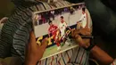 Asisten pelatih Indonesia, Kurniawan Dwi Yulianto, memberikan tanda tangan kepada fans asal Singapura di Hotel Peninsula, Singapura, Jumat (9/11). Indonesia akan melawan Singapura pada laga Piala AFF 2018. (Bola.com/M. Iqbal Ichsan)