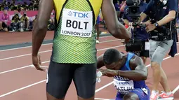 Pelari AS, Justin Gatlin berlutut di hadapan Usain Bolt usai menjadi juara pada lomba lari 100 meter Kejuaraan Dunia Atletik 2017 di Stadion London, Minggu (6/8). Itu dilakukan usai Gatlin dicemooh para penonton karena menjadi juara (AP/Matthias Schrader)