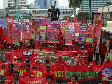 Ratusan buruh yang tergabung dalam Kongres Aliansi Serikat Buruh Indonesia (Kasbi) melakukan aksi long march membawa simbol tikus raksasa dari kawasan Bundaran HI menuju Istana Negara, Jakarta (31/10). (Liputan6.com/Johan Tallo)