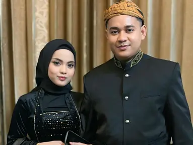 Putri Isnari membagikan potret terbarunya bareng suami ketika menghadiri prosesi siraman sekaligus mappaci calon suami Nia LIDA. Dalam momen bahagia tersebut, Putri tampil kompak dengan Abdul Azis mengenakan busana adat Jawa bernuansa hitam. (Liputan6.com/IG/@putriisnari3)