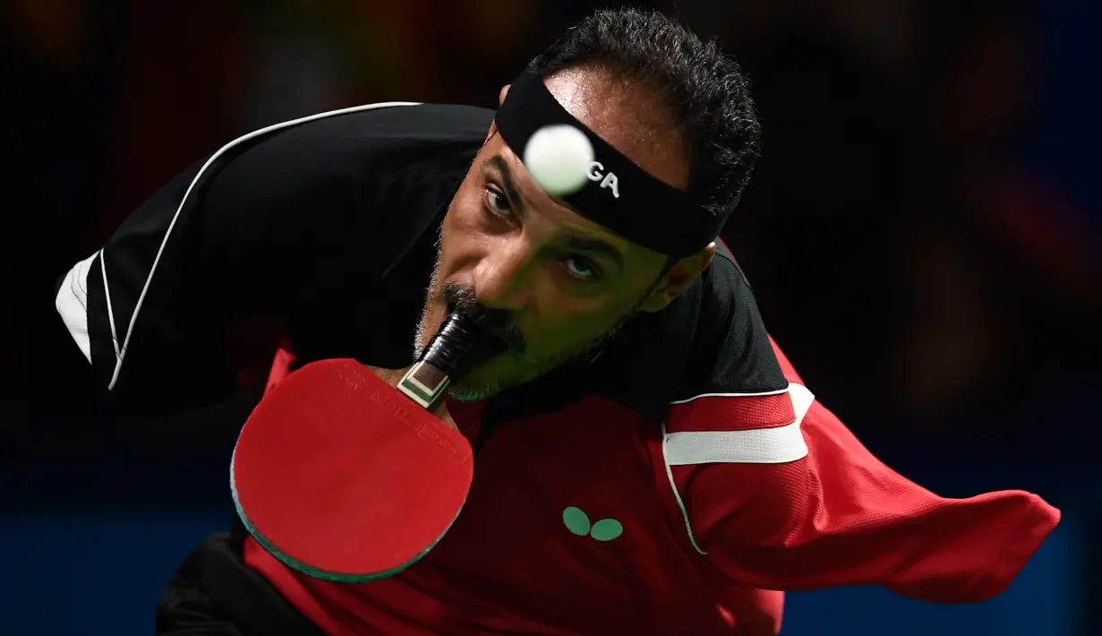 Ekspresi atlet asal Mesir, Ibrahim Hamadtou saat hendak memukul bola menggunakan mulutnya ke arah atlet asal Jerman, Thoma Rau pada cabang tenis meja tunggal putra di ajang Paralimpiade 2016, Rio de Janeiro, 9 September 2016. (CHRISTOPHE SIMON/AFP)