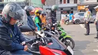 Para pengendara di Jalan Bundaran Tugu Adipura Kota Sukabumi, berhenti serentak menundukan kepala untuk mengheningkan cipta dalam peringati Hari Pahlawan Nasional (Liputan6.com/Fira Syahrin)