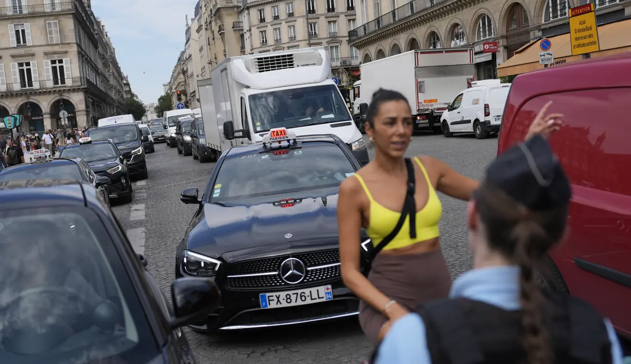 Para petugas dengan sabar menjelaskan kepada pengunjung yang tidak memiliki tiket masuk bagaimana cara mencapai monumen-monumen ikonik Paris tanpa melalui zona terlarang. (AP Photo/David Goldman)
