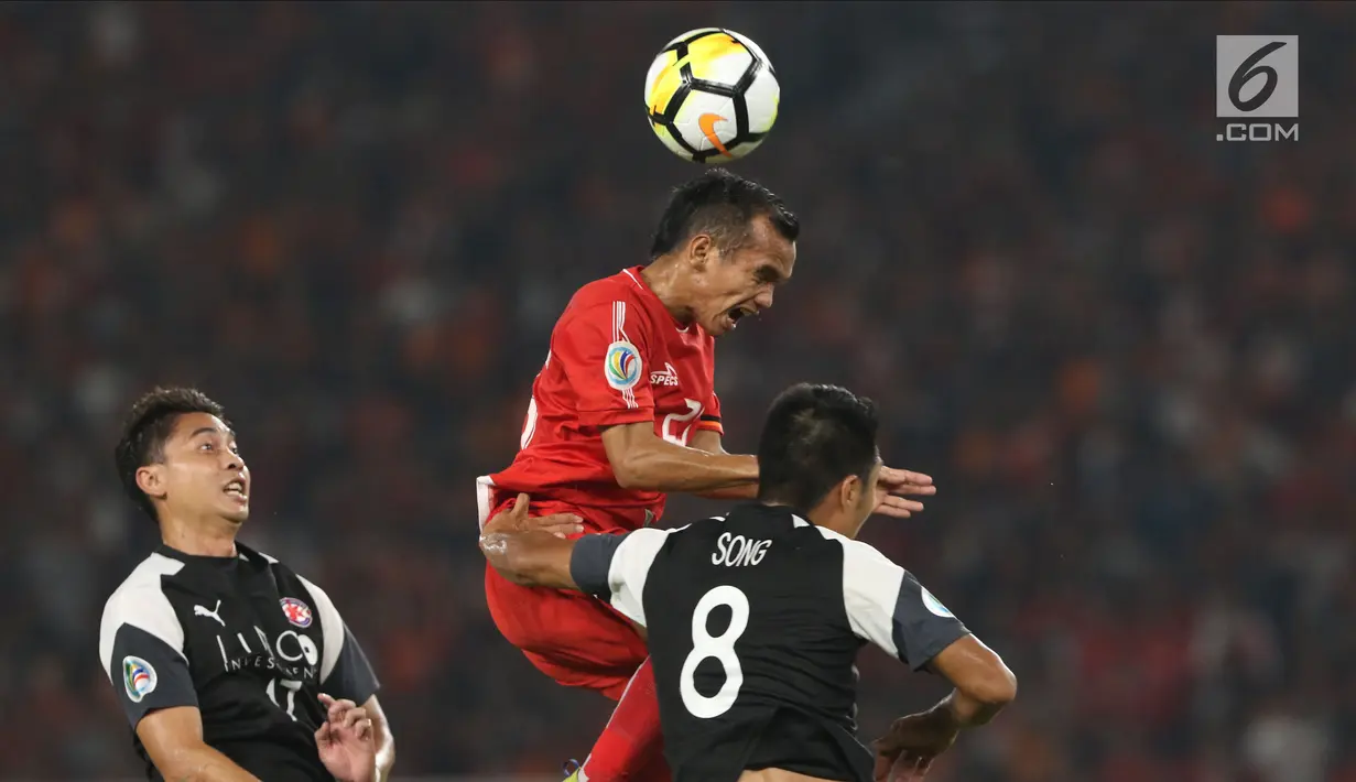 Pemain Persija, Riko Simanjuntak (tengah) berebut bola dengan pemain Home United saat laga kedua Semifinal Zona Asia Tenggara Piala AFC 2018 di Stadion GBK, Jakarta, Selasa (15/5). Babak pertama Persija tertinggal 1-3. (Liputan6.com/Helmi Fithriansyah)