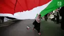 Anak kecil berlari di tengah bendera Palestina saat aksi di depan Kedubes AS, Jakarta, Jumat (23/6).  Aksi tersebut memperingati Al Quds Day 2017 sebagai dukungan bagi rakyat Palestina dan mengecam kebijakan AS dan Israel. (Liputan6.com/Faizal Fanani)