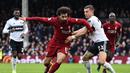 Aksi Mohamed Salah lewati gelandang Fulham, Joe Bryan pada laga lanjutan Premier League yang berlangsung di Stadion Craven Cottage, London, Minggu (17/3). Liverpool menang 2-1 atas Fulham. (AFP/Glyn Kirk)