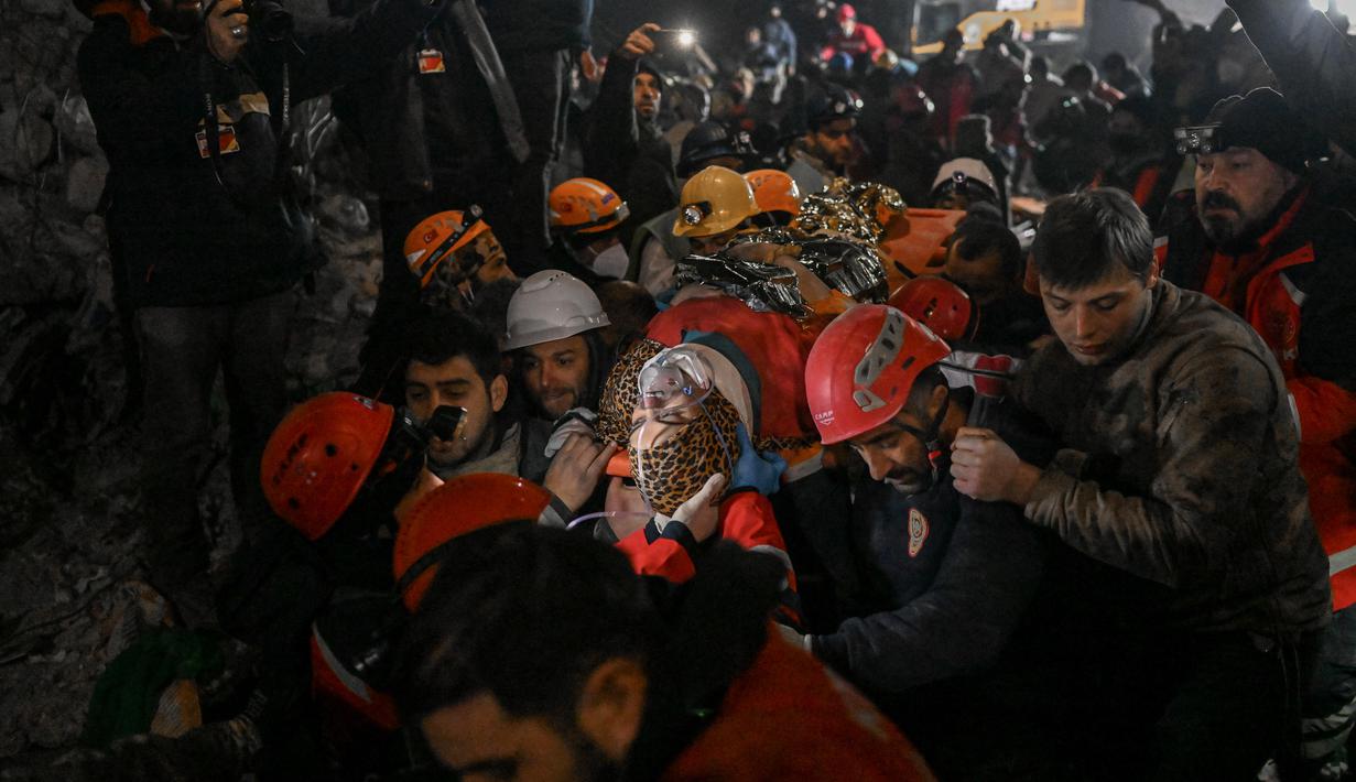 Seher, seorang wanita Suriah berusia 15 tahun yang diselamatkan oleh petugas penyelamat dari bawah reruntuhan dibawa ke ambulans di Hatay, Turki tenggara, pada 14 Februari 2023. Seher berhasil diselamatkan setelah terperangkap di bawah reruntuhan selama 210 jam seminggu setelah gempa mematikan melanda sebagian dari Turki dan Suriah. (AFP/Yasin AKGUL)
