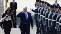 Donald Trump memberi hormat kepada pasukan kehormatan saat tiba bersama ibu negara, Melania Trump, di Bandara Stansted di Inggris, 3 Juni 2019. (AP)