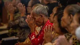 Misa Malam Natal 2025 di gereja ini dilaksanakan dalam dua sesi. Pertama, pada pukul 16.00 WIB dengan menggunakan bahasa Jawa. Dan yang kedua, pukul 20.00 WIB dengan bahasa Indonesia. Tampak dalam foto, para umat Katolik yang mengenakan pakaian tradisional Jawa menghadiri Misa Malam Natal di Gereja Hati Kudus Yesus di Ganjuran, Bantul, Yogyakarta, pada Rabu 24 Desember 2025. (DEVI RAHMAN/AFP)
