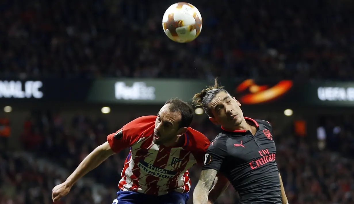 Pemain Arsenal, Hector Bellerin (kanan) dan pemain Atletico, Diego Godin melakukan duel  pada semifinal Liga Europa di Wanda Metropolitano stadium, Madrid, (3/5/2018). Atletico menang 1-0. (AP/Francisco Seco)