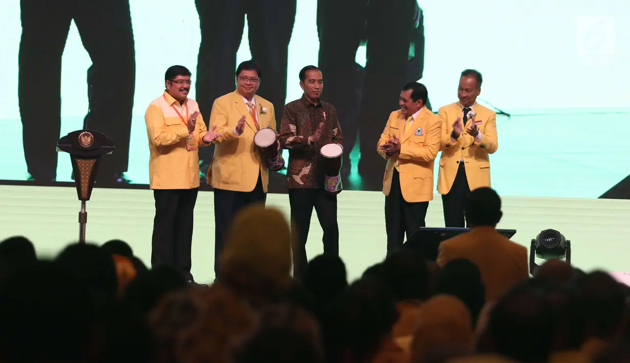 Presiden Joko Widodo (tengah) bersama Ketua Umum Partai Golkar Airlangga Hartarto (kedua kiri) memukul Tifa saat membuka Musyawarah Nasional Luar Biasa (Munaslub) Partai Golkar di Jakarta, Senin (18/12). (Liputan6.com/Angga Yuniar)
