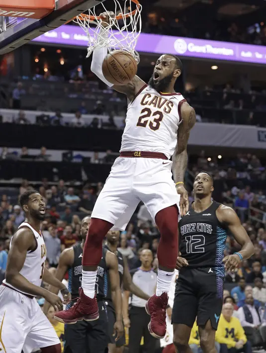 Pebasket Cleveland Cavaliers, LeBron James, memasukkan bola saat pertandingan melawan Charlotte Hornets pada laga NBA di Spectrum Center, Rabu (28/3/2018). Cleveland Cavaliers menang 118-105 atas Charlotte Hornets. (AP/Chuck Burton)