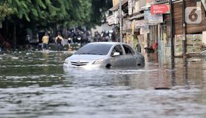 Sebuah mobil terjebak banjir di Jalan RA Kartini, Bekasi, Jawa Barat, Kamis (2/1/2020). Banjir yang merendam Jalan RA Kartini sejak kemarin melumpuhkan akses kendaraan dan perekonomian warga setempat. (merdeka.com/Iqbal Nugroho)