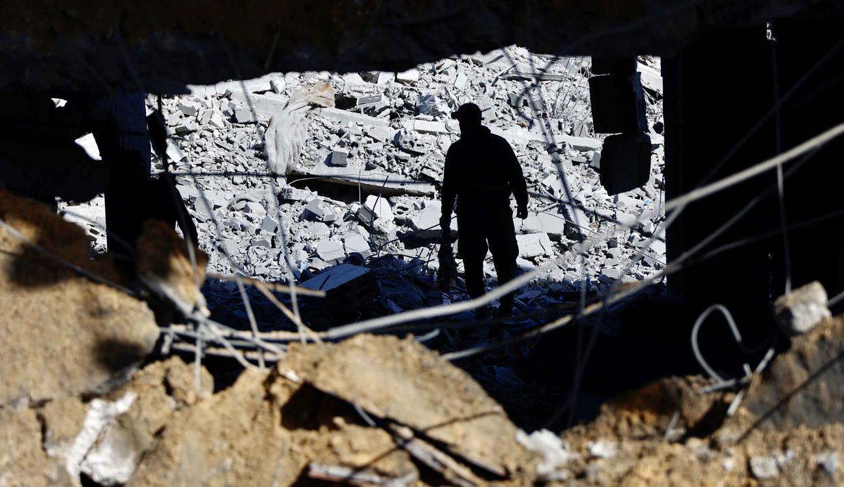 Sementara, kelompok Hamas mengecam keras serangan tersebut dan mendesak Amerika Serikat untuk segera turun tangan. Tampak dalam foto, seorang pria memeriksa puing-puing kantor polisi Sheikh Radwan di Kota Gaza pada 31 Januari 2026. (Omar AL-QATTAA/AFP)