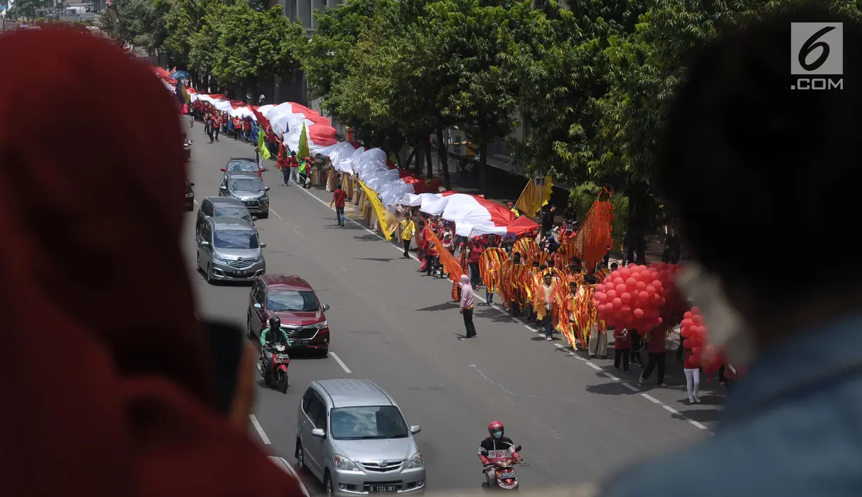 Warga menyaksikan kirab perayaan Paskah di Jalan MH Thamrin, Jakarta, Minggu (4/1). Kirab ini dimulai dari Bundaran Hotel Indonesia dan berakhir di gereja Immanuel Jakarta. (Liputan6.com/Helmi Fithriansyah)