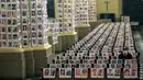 Petugas keamanan duduk di antara potret korban meninggal akibat virus corona di dalam Katedral, di Lima, Peru pada 13 Juni 2020. Misa Minggu di Katedral Lima dihadiri lebih dari 4.000 potret mereka yang telah meninggal dalam pandemi Covid-19 yang menyebar di Peru. (AP Photo/Rodrigo Abd)