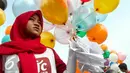 Seorang aktivis perempuan bersiap melepaskan surat pesawat kertas yang diikatkan dengan balon, Jakarta, Minggu (29/5/2016). Surat pesawat kertas tersebut ditujukan untuk Jokowi agar melindungi anak Indonesia dari bahaya rokok. (Liputan6.com/Yoppy Renato) 