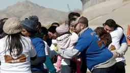 Suasana haru saat warga Meksiko bertemu keluarga dan kerabat mereka di perbatasan Meksiko-AS di Ciudad Juarez, Meksiko (28/1). Dengan waktu yang singkat, akhirnya mereka dapat melepas rindu setelah lama berpisah. (AP Photo/Christian Torres)