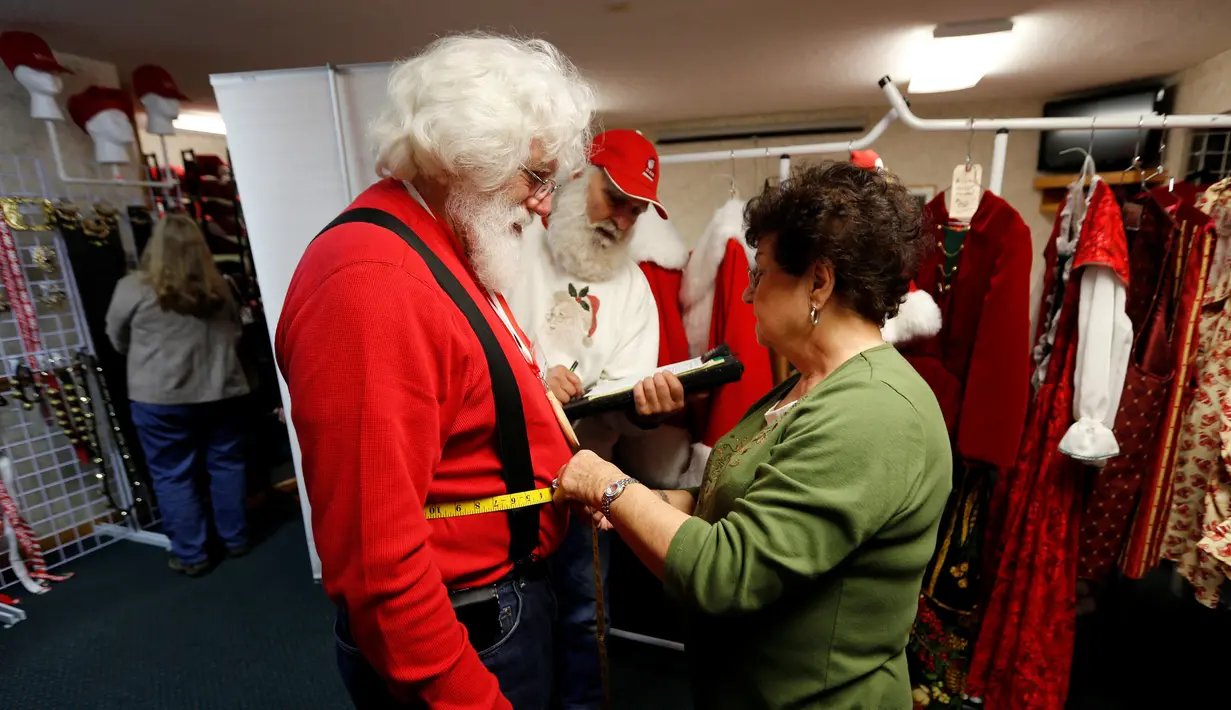 Siswa mengukur kostum Santa Claus saat mengikuti kelas di Charles W. Howard Santa Claus School di Midland, Michigan, 27 Oktober 2016. Mereka diberi beragam pelajaran dari merias wajah, sampai pendidikan mengenai merawat rusa. (REUTERS/Christinne Muschi)