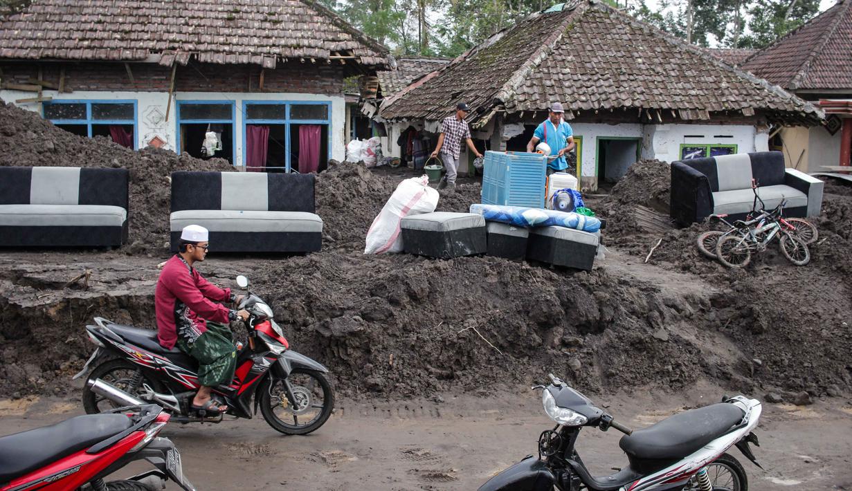 Bahkan, sebagian di antaranya rata dengan fondasi tanah disapu material vulkanik. Tampak dalam foto, warga menyelamatkan barang-barang dari sebuah rumah yang hancur akibat aliran piroklastik Gunung Semeru di Desa Supiturang, Lumajang, Jawa Timur, pada Jumat 21 November 2025. (Agus Harianto/AFP)