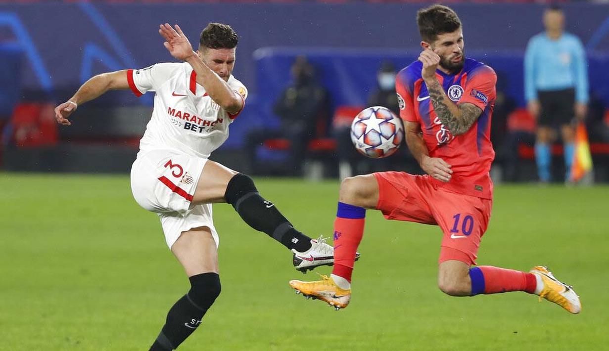 Gelandang Chelsea, Christian Pulisic, berusaha menghadang tendangan pemain Sevilla, Sergi Gomez, pada laga Liga Champions di Stadion Ramon Sanchez Pijuan, Kamis (3/12/2020). Chelsea Menang dengan skor 4-0. (AP/Angel Fernandez)