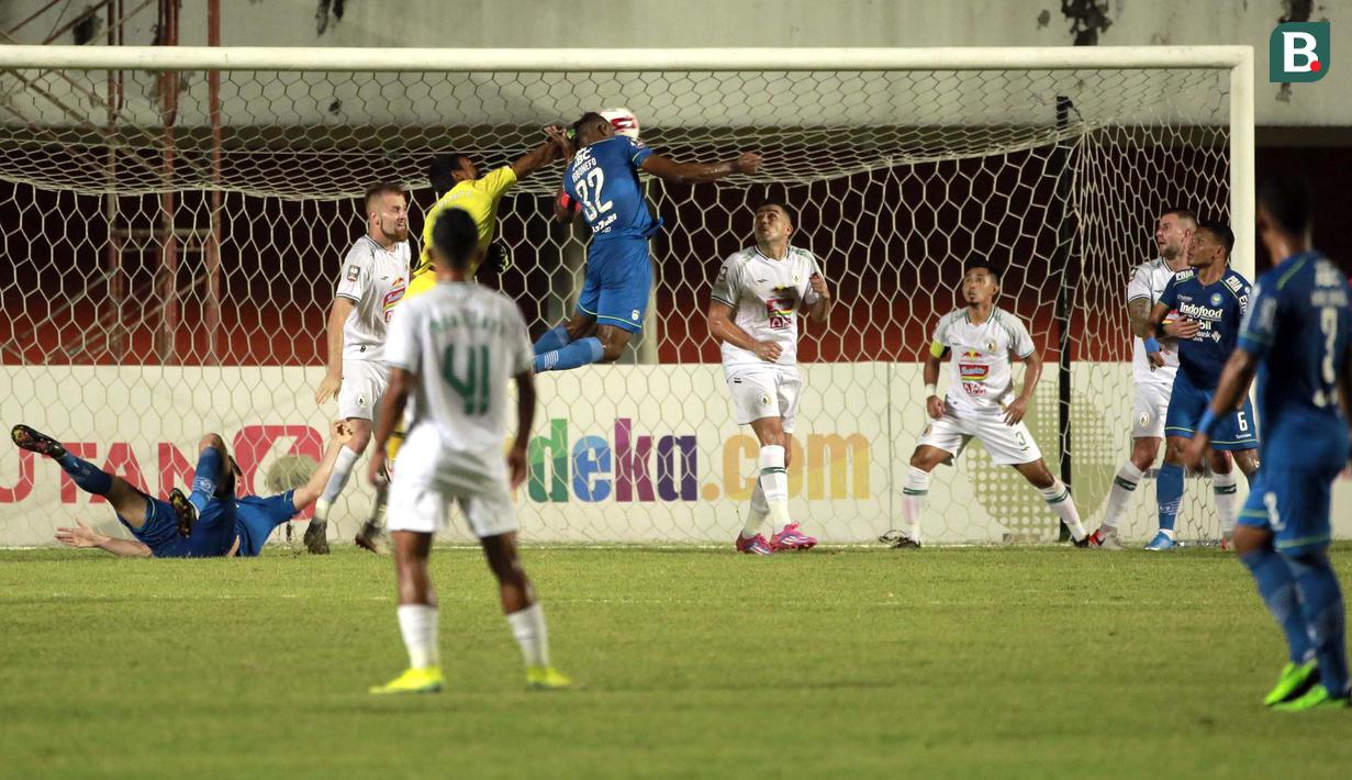 Pemain Persib Bandung, Victor Igbonefo (tengah) menyundul bola yang menghasilkan gol ke gawang PS Sleman dalam laga leg pertama semifinal Piala Menpora 2021 di Stadion Maguwoharjo, Sleman, Jumat (16/4/2021). (Bola.com/Ikhwan Yanuar)