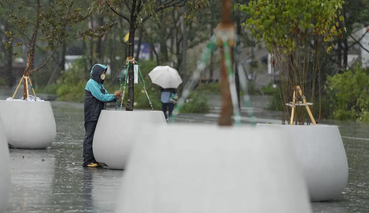 Seorang pekerja memeriksa fasilitas di alun-alun saat Topan Hinnamnor bergerak menuju Semenanjung Korea di Seoul, Korea Selatan, Senin (5/9/2022). Pemerintah juga menyarankan agar sekolah ditutup dan dialihkan menjadi pembelajaran daring.  (AP Photo/Lee Jin-man)
