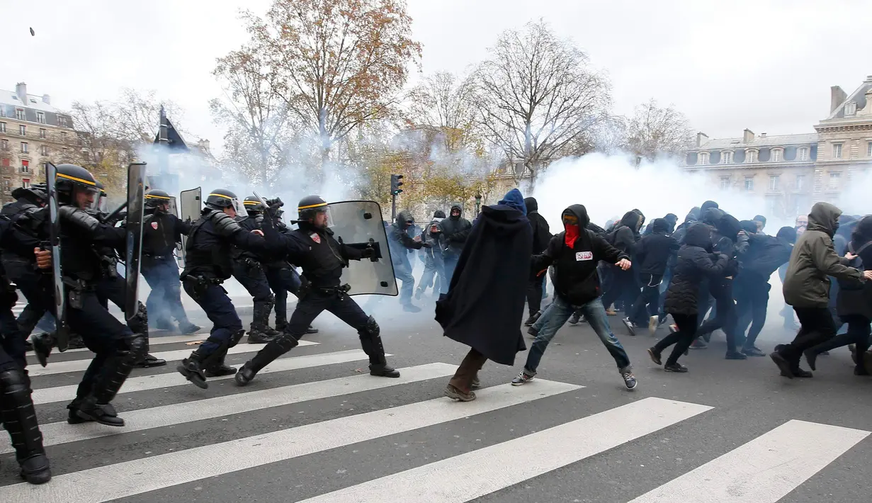 Polisi menembakkan gas air mata ke demonstran menjelang Konferensi Perubahan Iklim Dunia 2015 di Place de la Republique Paris, Prancis, Minggu (29/11). Paris melarang semua aksi demonstrasi pasca teror beberapa waktu lalu. (REUTERS/Eric Gaillard)