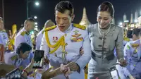 Raja Maha Vajiralongkorn dan Ratu Suthida menyapa pendukungnya di Bangkok, Thailand, Minggu (1/11/2020). Di bawah tekanan yang meningkat dari pengunjuk rasa yang menuntut reformasi pada monarki, Raja dan Ratu Thailand bertemu dengan ribuan pendukung yang memujanya. (AP Photo/Wason Wanichakorn)