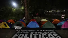 Tenda-tenda yang didirikan oleh kerabat tahanan politik terlihat di luar penjara El Rodeo I di Guatire, Negara Bagian Miranda, sekitar 30 kilometer sebelah timur Caracas, Venezuela, pada 12 Januari 2026. Warga Venezuela masih menanti pembebasan lebih banyak tahanan politik yang dipenjara atas perintah Presiden Nicolas Maduro. (Pedro MATTEY/AFP)