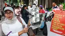 Seorang perempuan memukul peralatan dapur saat melakukan protes menuntut pemerintah meninjau kembali program Makan Bergizi Gratis (MBG), menurunkan harga Bahan Bakar Minyak (BBM), dan membuka lebih banyak lapangan kerja bagi perempuan, di Jakarta, Kamis 18 Juni 2026. (BAY ISMOYO/AFP)