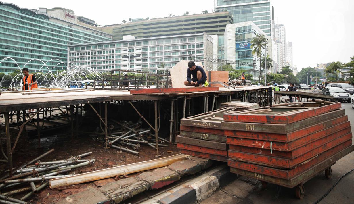 Pekerja menyelesaikan pembuatan panggung untuk acara malam tahun baru di sekitar kawasan Bundaran HI, Jakarta, Rabu (25/12/2019). Merayakan pergantian tahun, Pemprov DKI Jakarta menggelar sejumlah acara di sejumlah titik sepanjang Jalan Sudirman-MH Thamrin. (Liputan6.com/Faizal Fanani)