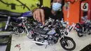 Deretan miniatur motor yang dipajang di Kampung Dukuh, Serua, Tangerang Selatan, Sabtu (17/10/2020). Miniatur motor dengan rasio 1:18 yang dikerjakan sendiri mampu memproduksi 1 buah dalam jangka waktu dua hari. (Liputan6.com/Fery Pradolo)