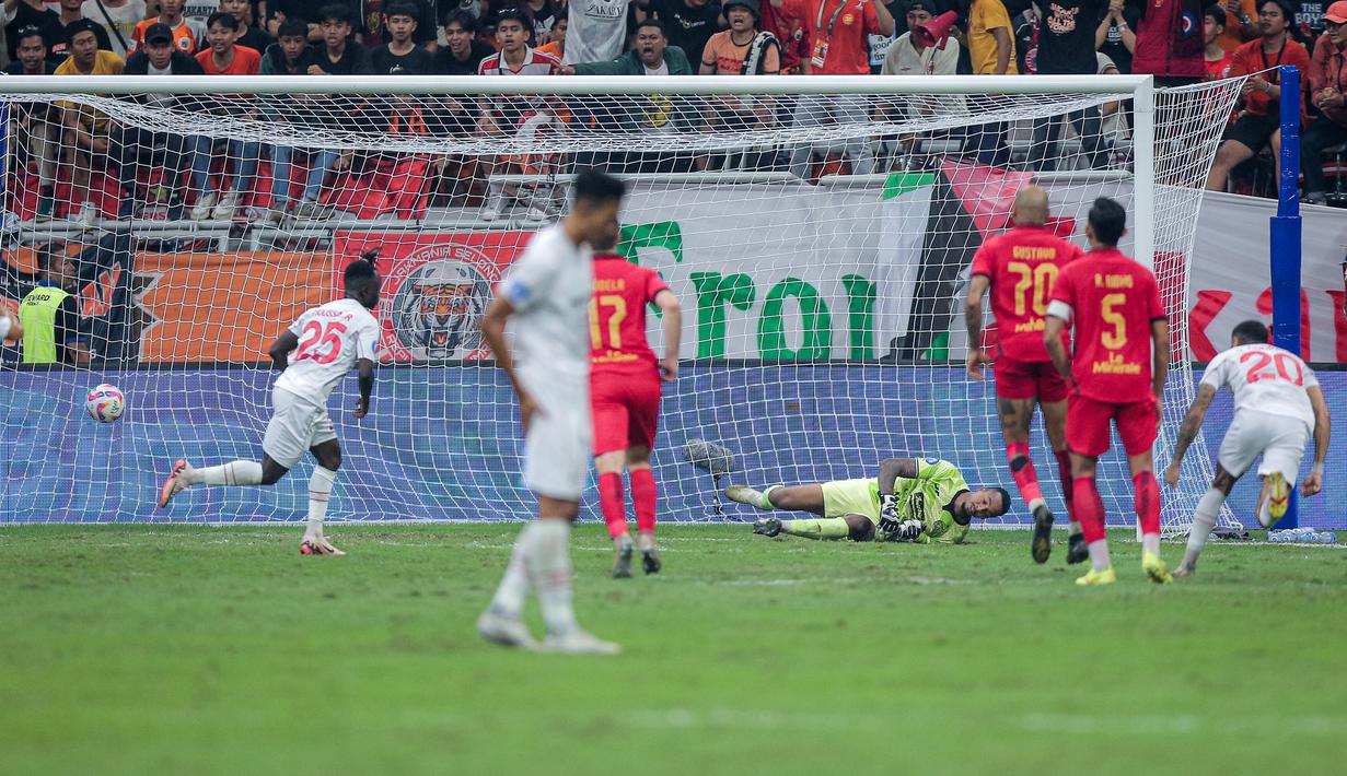 Kiper Persija Jakarta, Carlos Eduardo Saores (kanan) gagal menghalau bola tendangan penalti pemain Persis Solo, Moussa Sidibe pada laga lanjutan BRI Liga 1 2024/2025 di Jakarta International Stadium (JIS), Jakarta Utara, Sabtu (24/08/2024). (Bola.com/Bagaskara Lazuardi)