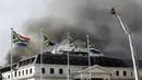 Asap mengepul dari Gedung Parlemen di Cape Town, Afrika Selatan, 3 Januari 2022. ​Setelah sempat berhasil dipadamkan, api kembali mengamuk dan membakar Gedung Parlemen Afrika Selatan. (AP Photo/Nardus Engelbrecht)