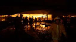 Petugas pemadam kebakaran mencoba memadamkan api di sebuah mal setelah gempa bumi melanda General Santos City, di pulau selatan Mindanao, Kamis (16/10/2019). Sejumlah bangunan dilaporkan roboh dan jaringan listrik putus usai gempa bermagnitudo 6,4 mengguncang Filipina selatan. (EDWIN ESPEJO / AFP)