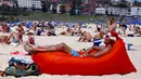 Seorang turis pria berjemur saat merayakan hari Natal di Bondi Beach Sydney pada Hari Natal di Australia, (25/12). (REUTERS/David Gray)