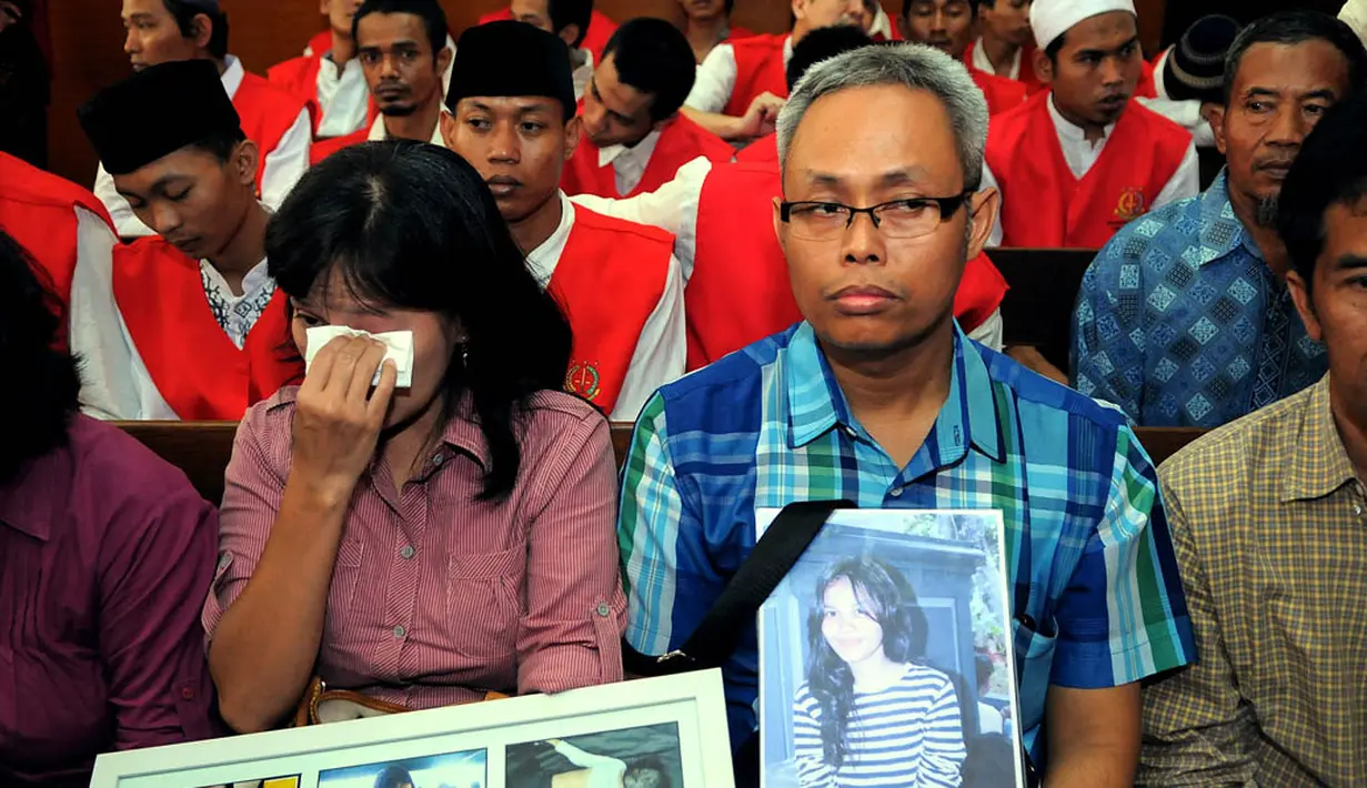 Orangtua Ade Sara memegang foto mendiang putri mereka saat mengikuti persidangan di Pengadilan Negeri Jakarta Pusat, (16/9/14). (Liputan6.com/Faisal R Syam)